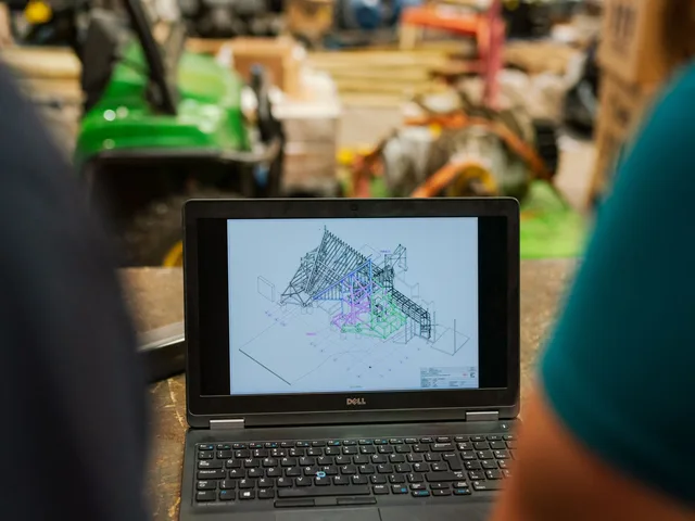 Szakember laptopon 3D gyártási rajzot ellenőriz az üzemcsarnokban